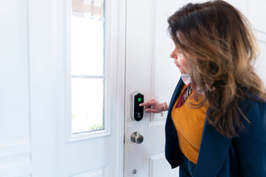 Homeowner easily locks her front door by a simple touch with smart lock.